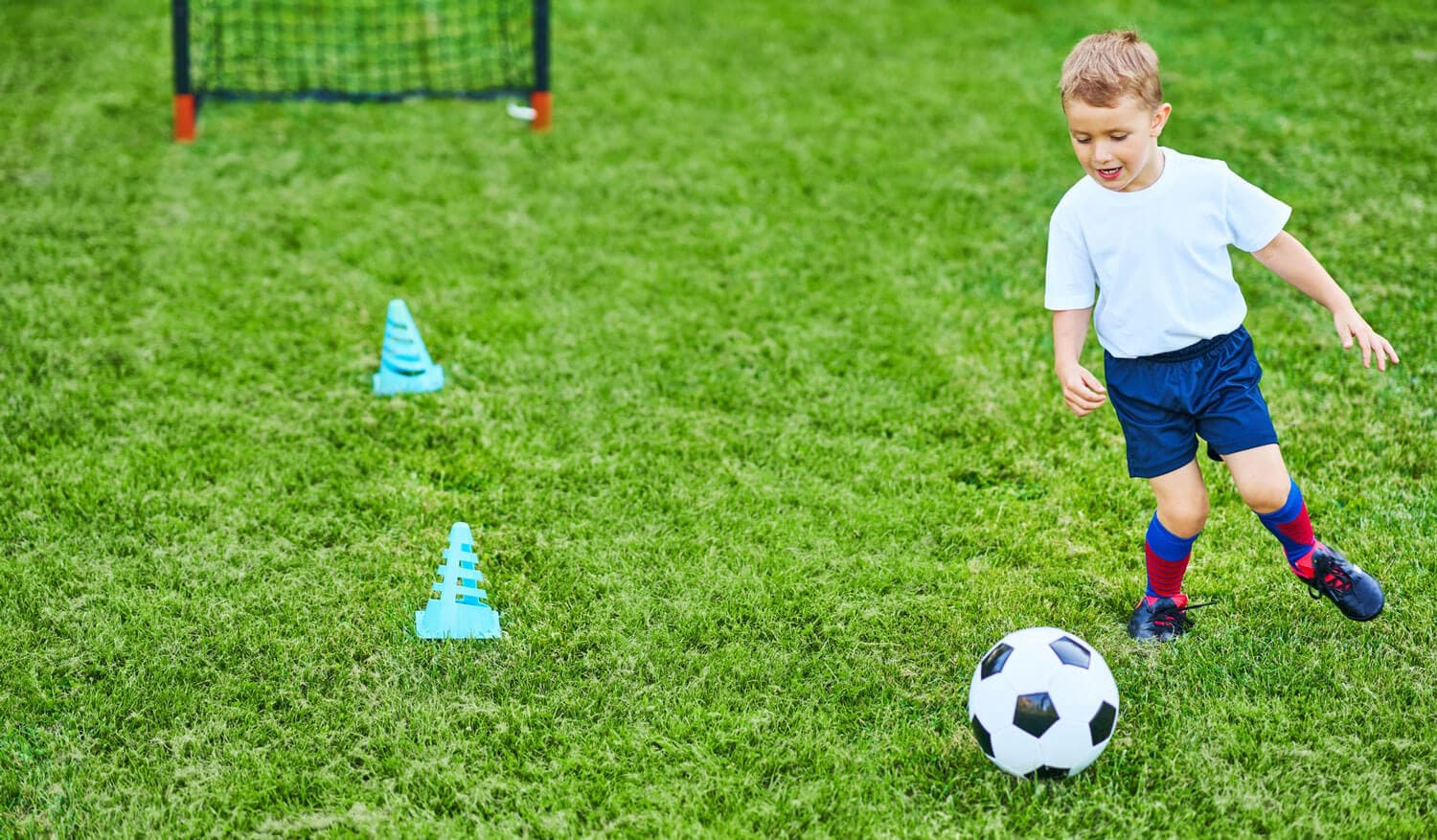 Child dribbling a soccer ball during an enrichment activity at Creation Kingdom